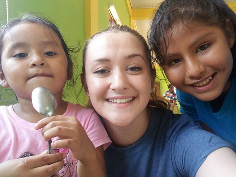 A Penn State 阿尔图纳 Enactus student with children in Bolivia